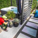 man-arranging-plants-near-hot-tub-in-backyard-2026-01-09-01-10-18-utc-2